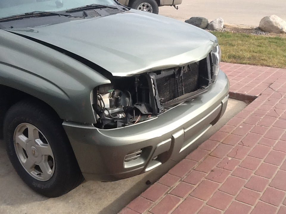 Damaged vehicle front after deer collision, requiring auto body repair.